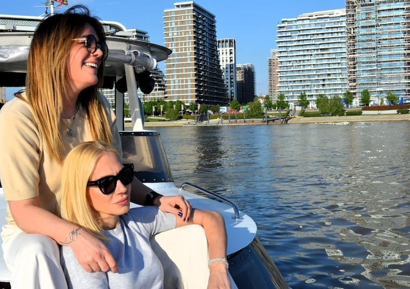Deux personnes à bord d’un bateau, avec une vue sur la ville en arrière-plan. 2