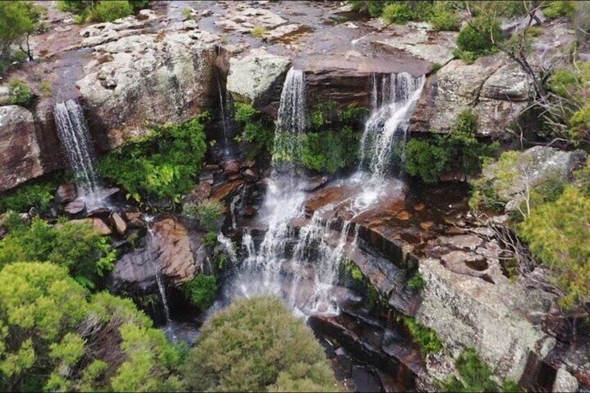 A multi-tiered waterfall surrounded by lush greenery. 4