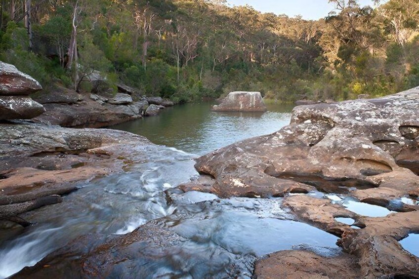 A river flowing through a rocky landscape with trees in the background. 3