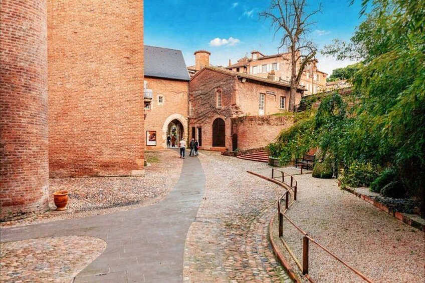 A cobblestone path, brick buildings, and a clear sky. 3