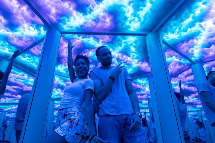 A person standing inside a structure with a ceiling that has a cloud-like pattern. 1