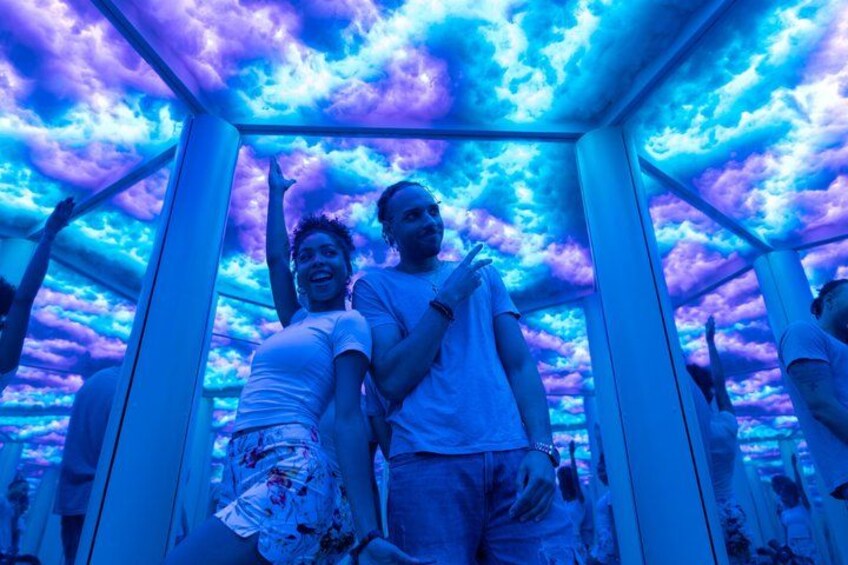 A person standing inside a structure with a ceiling that has a cloud-like pattern. 1