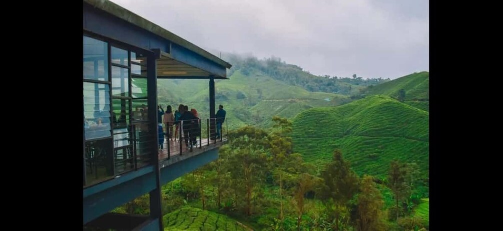 A glass-roofed terrace overlooking lush green hills. 3