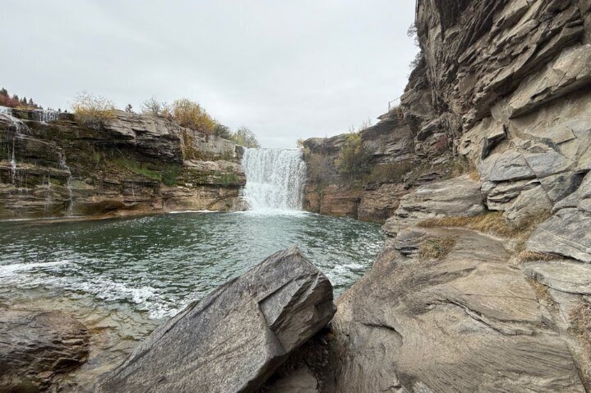 Une cascade se jetant dans une rivière, entourée de falaises rocheuses. 2
