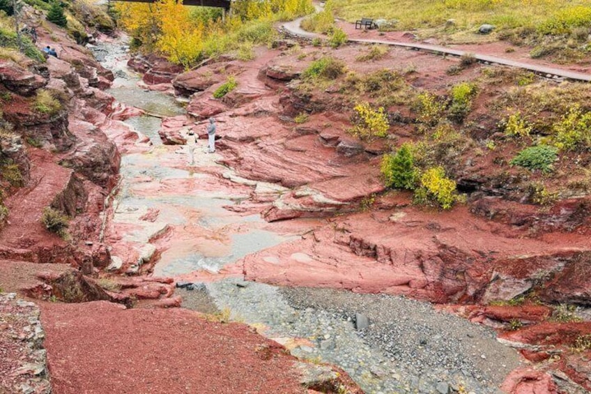 Un paysage de roches rouges, avec un ruisseau et un sentier pédestre. 1