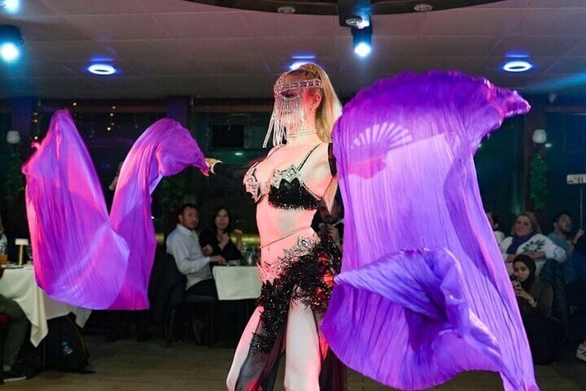 A person performing an act with purple fabric. 5