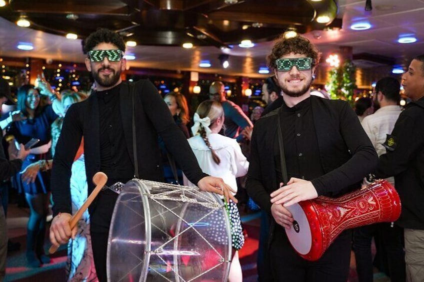 Two individuals playing drums at a social event. 3