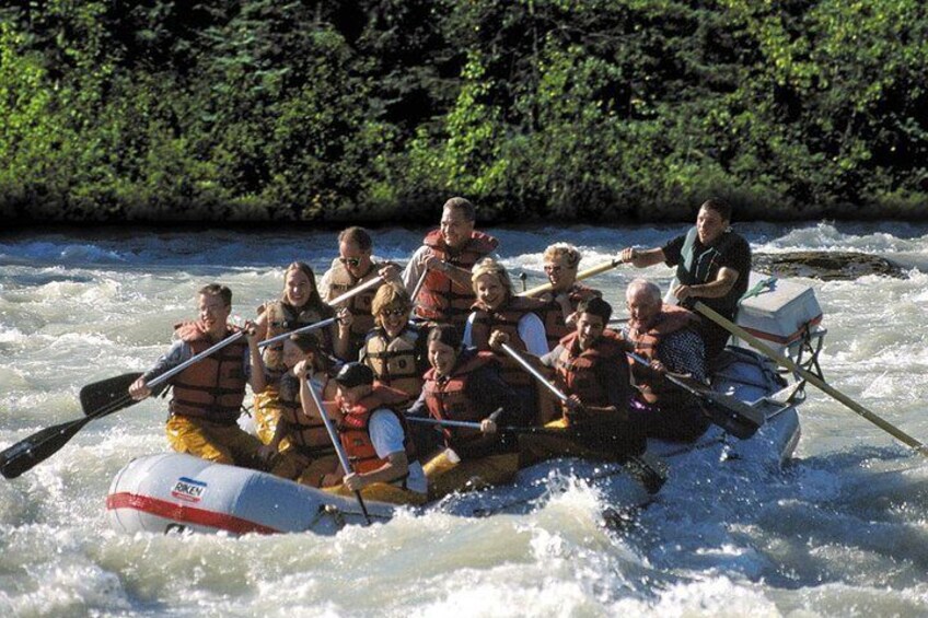 A group of people in a raft navigating a river. 2