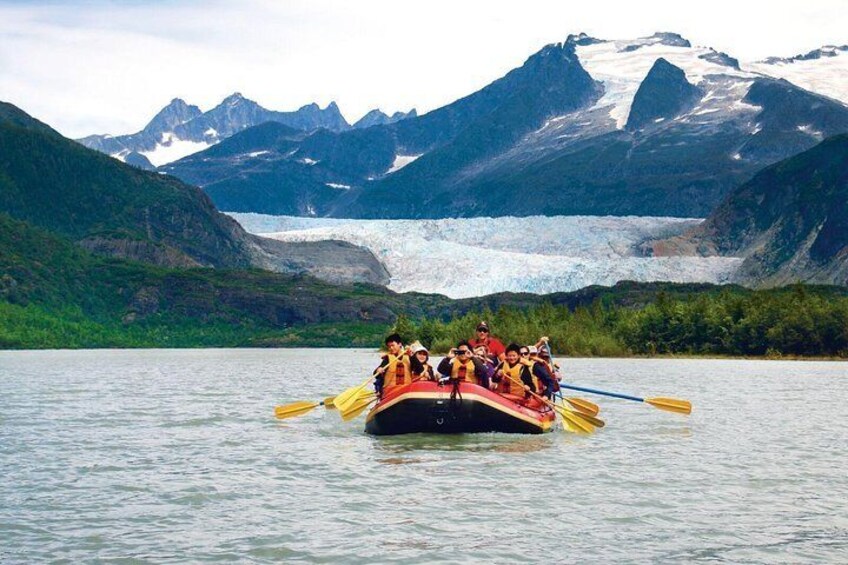 A group of people on a boat with a glacier in the background. 1