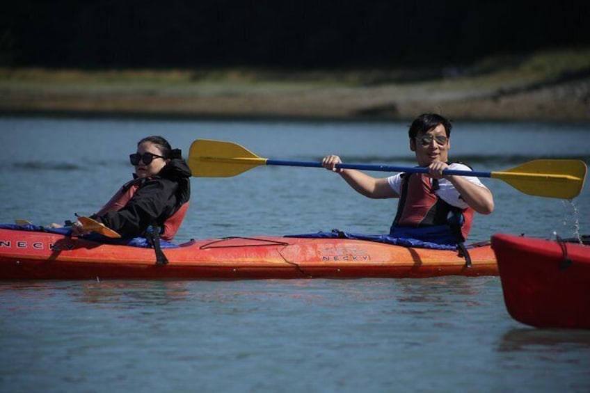 Twee mensen kajakken op een kalm wateroppervlak. 3