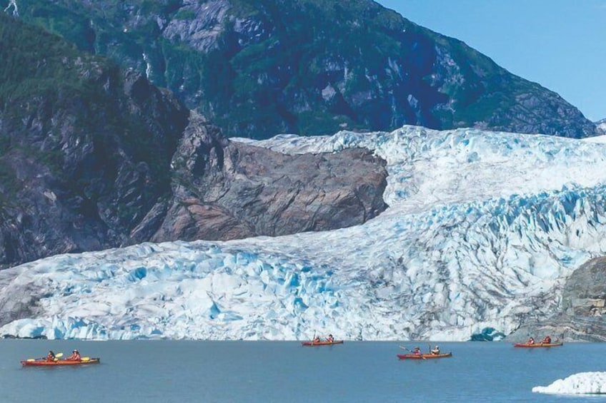 Un glaciar con kayaks en el agua. 1