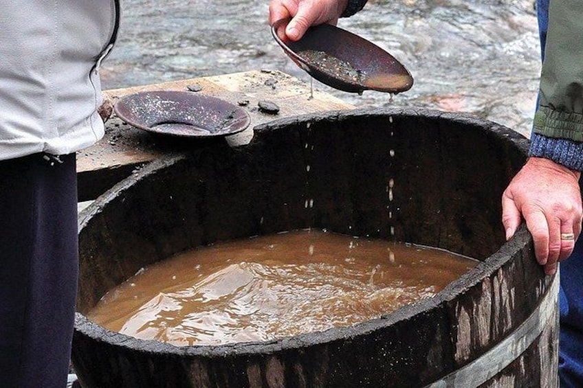 Une personne verse un liquide d’une casserole dans un grand tonneau en bois. 5