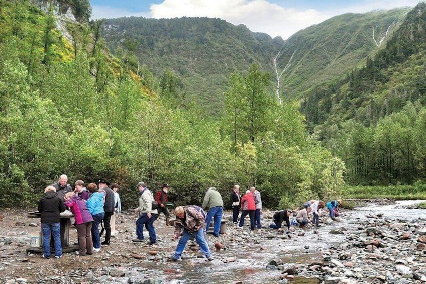 Un groupe de personnes se trouve au bord d’une rivière, dans une région montagneuse. 2