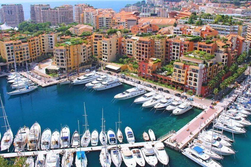 A marina with numerous boats docked, surrounded by residential buildings with red roofs. 4