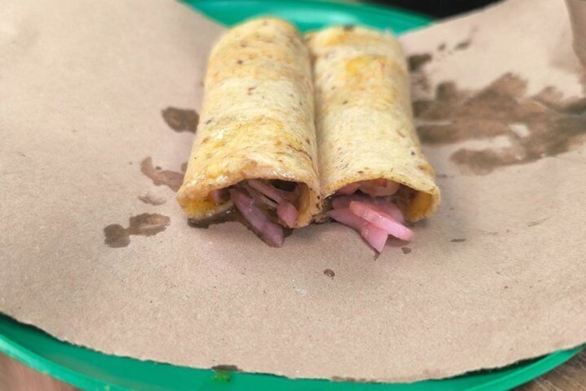 Un burrito garni de viande et de fromage, servi sur une assiette en papier. 5