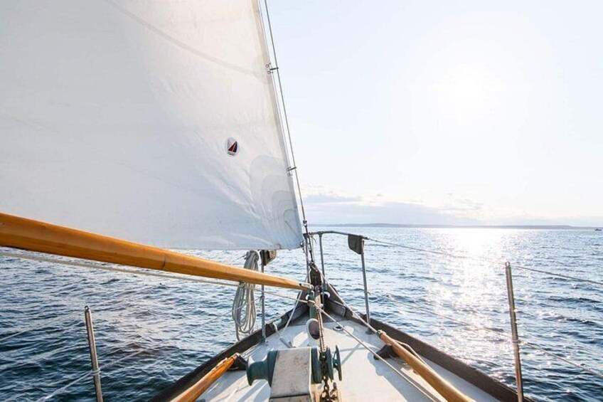 Un voilier à la voile blanche sur une mer calme. 1