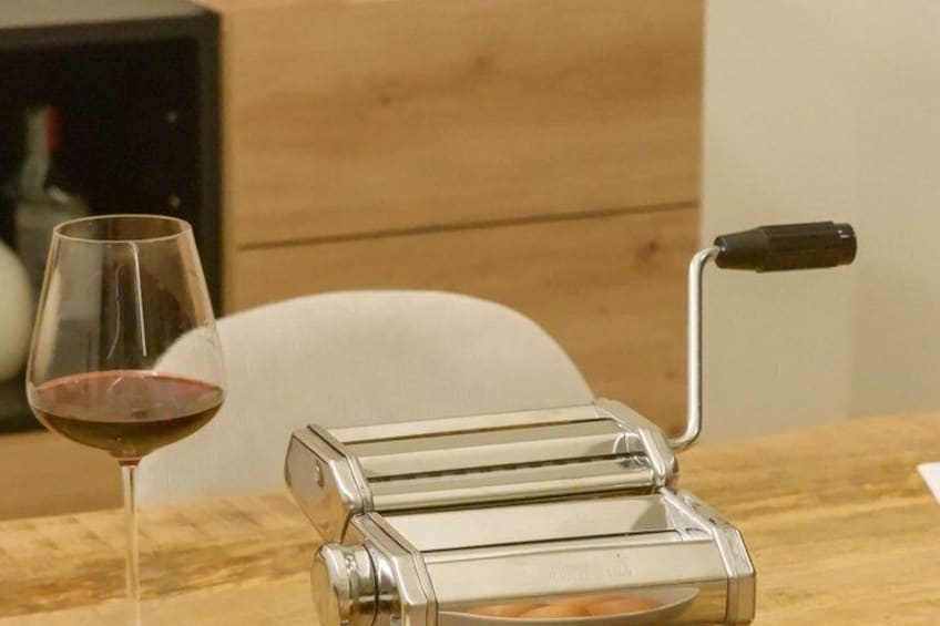 A clear glass kitchen appliance, possibly a toaster, on a wooden table with a wine glass nearby. 5