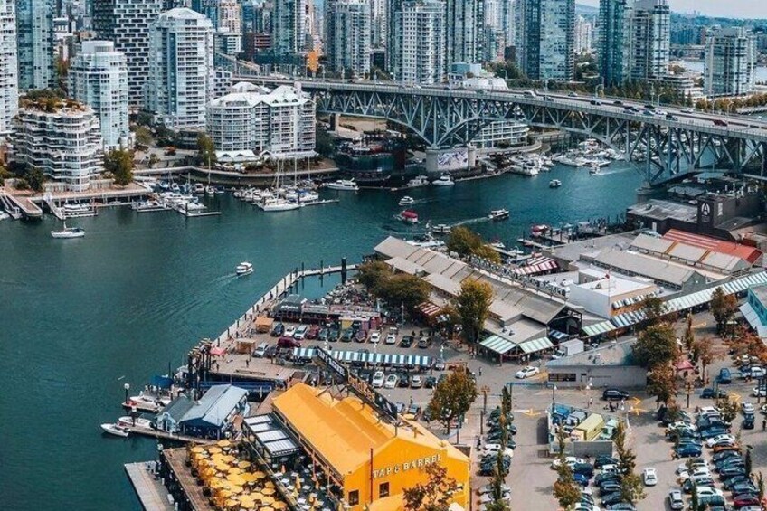 A waterfront area with a bridge, high-rise buildings, and a marina with boats. 4
