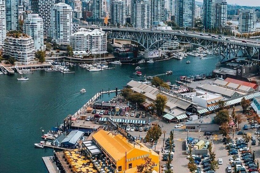 A waterfront area with a bridge, high-rise buildings, and a marina with boats. 4