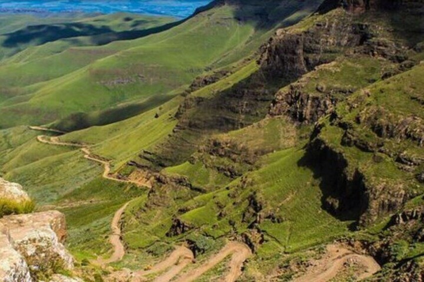 A mountainous landscape with winding paths and green valleys. 3