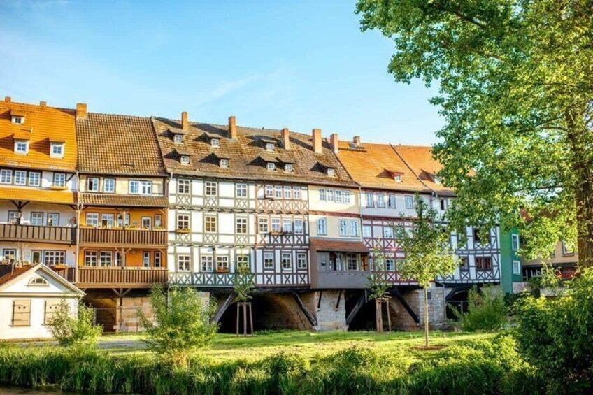 Eine Reihe traditioneller Fachwerkhäuser mit einer Brücke im Vordergrund. 3