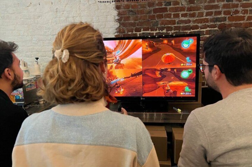 Three people watching a video game on a TV. 5