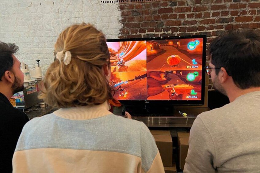 Three people watching a video game on a television. 5