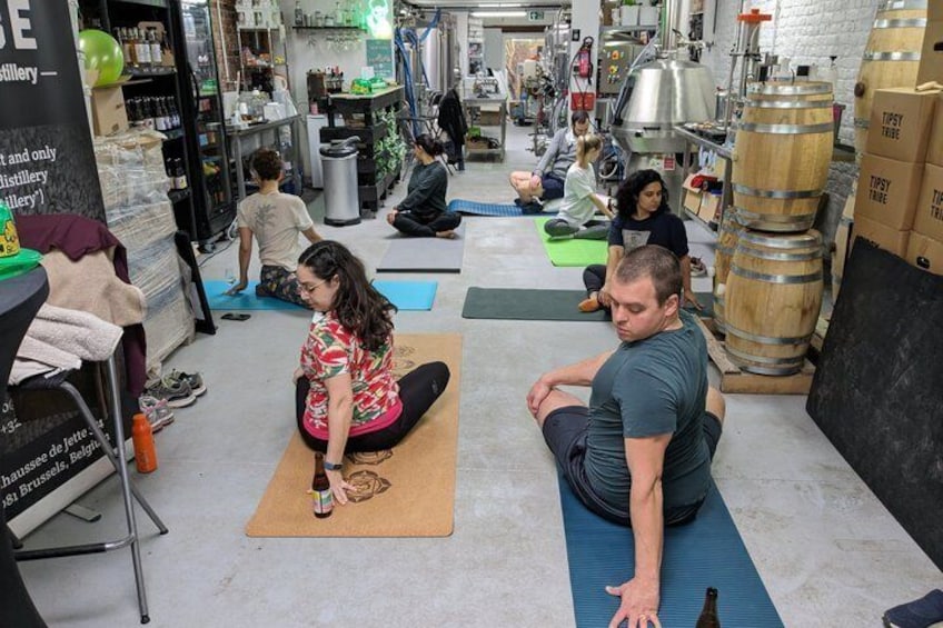 People exercising on mats in a studio with equipment and barrels. 5
