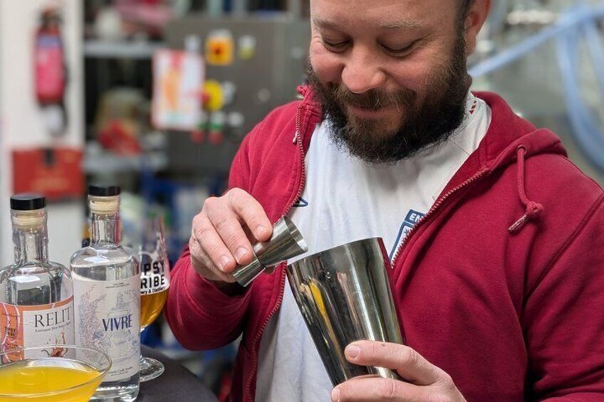 A person pouring a liquid from a bottle into a metal container. 5