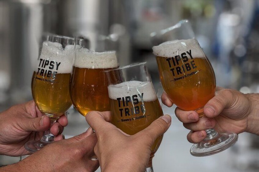 Four people holding glasses of beer with 'TIPSY TRIBE' branding. 5
