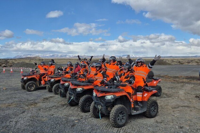 A group of people on ATVs in a barren landscape with mountains in the background. 5