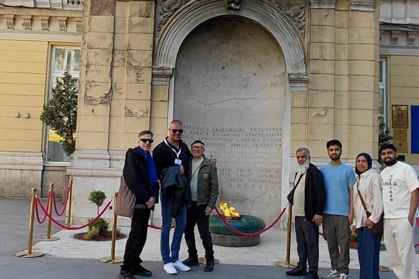 A group of people standing in front of a historical monument with inscriptions. 5