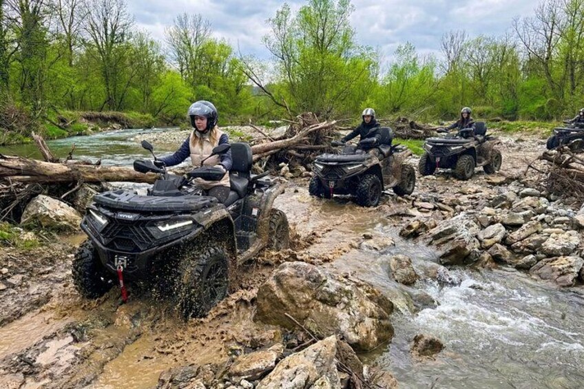 Geländewagen befahren ein steiniges Flussbett. 1