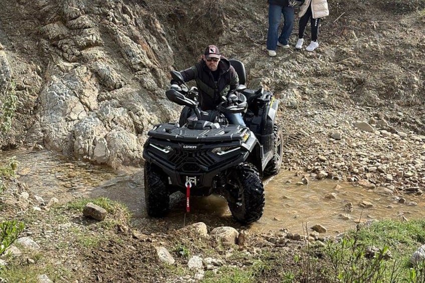A person on a quad bike navigating a rocky terrain. 2