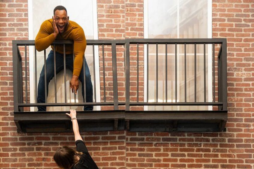 Une personne qui tend la main vers la balustrade d’un balcon. 2