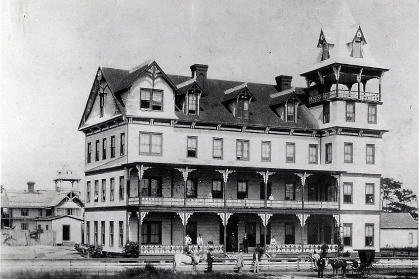 Ein großes, mehrstöckiges Gebäude mit einem markanten Turm und einem Balkon. 2
