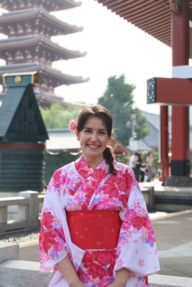 A person in a kimono with a floral pattern, standing in front of a traditional Japanese pagoda. 4
