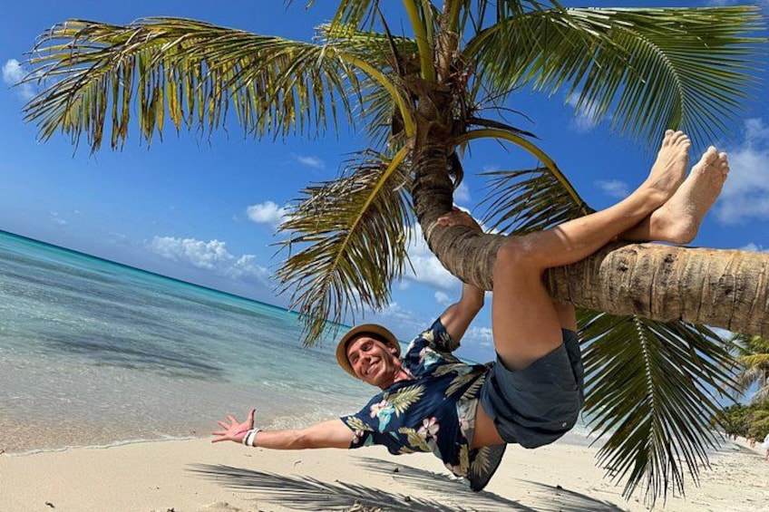 En person som ligger på en strand under ett palmträd. 1