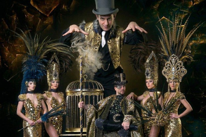 A group of people in elaborate costumes with a birdcage and smoke effects. 1