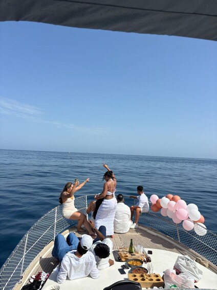 A group of people on a boat with a clear view of the ocean. 4