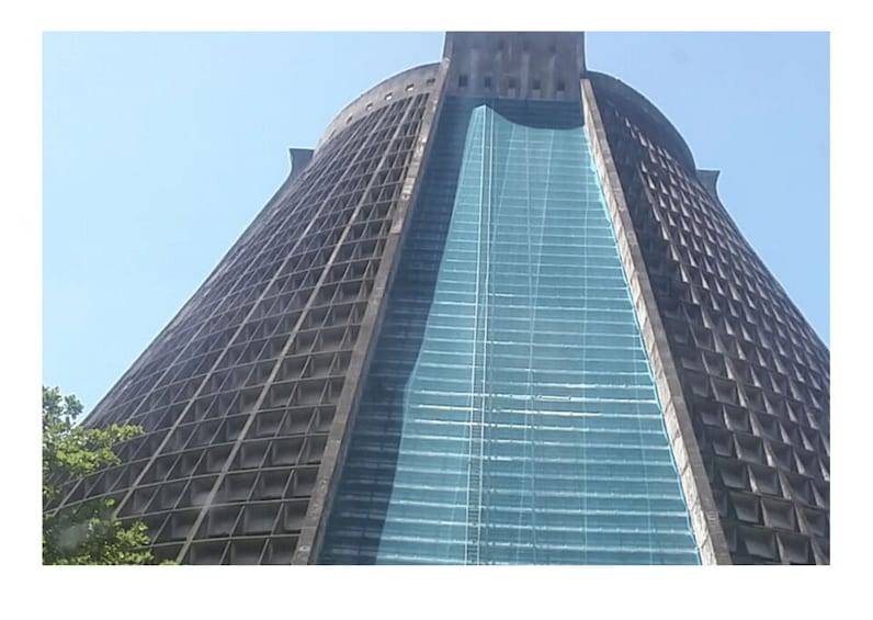 A tall, modern skyscraper with a glass facade and a unique angular design. 4