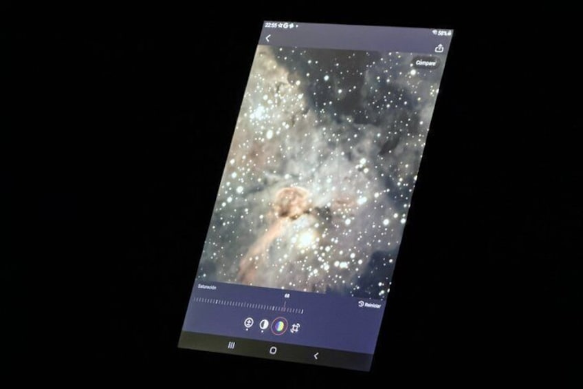 Ein Smartphone, das einen Sternenhimmel mit einer sichtbaren Galaxie zeigt. 5