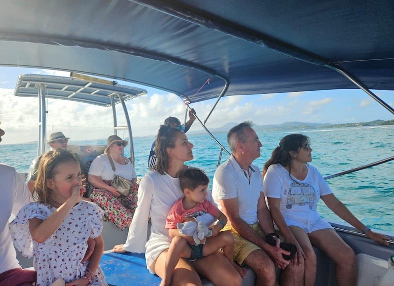 A family on a boat with a clear view of the sea and distant land. 5
