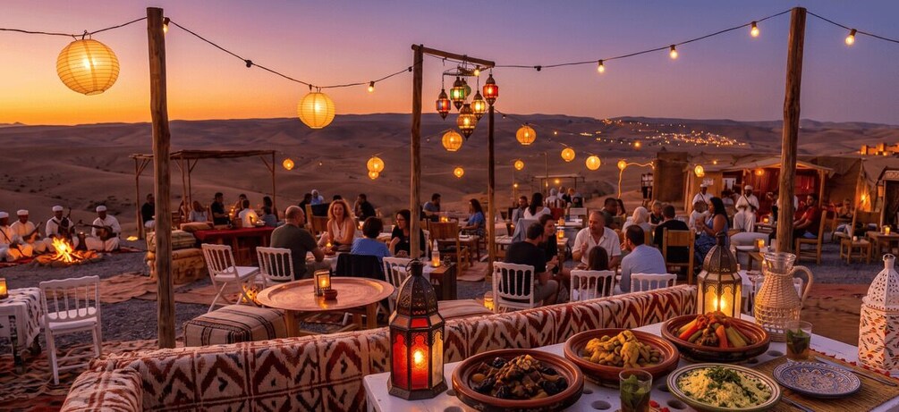 An outdoor dining area with tables, chairs, and lanterns against a desert backdrop. 4