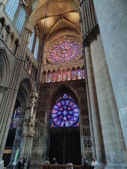 A cathedral interior with Gothic architecture, stained glass windows, and a large rose window. 4
