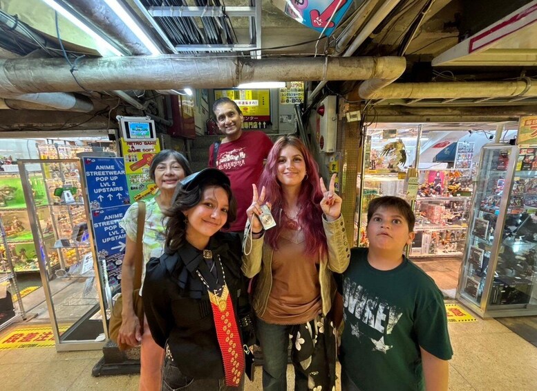 A group of people standing in front of a store with anime merchandise. 2