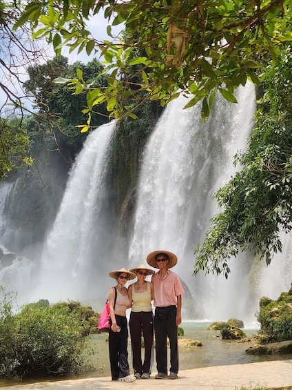 A waterfall with people standing in front of it. 2