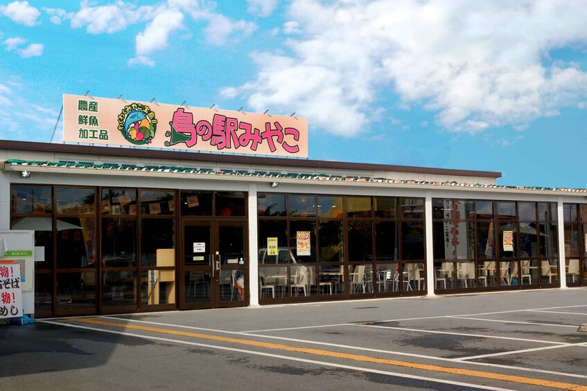 A restaurant with a large signboard and a parking lot in front. 4