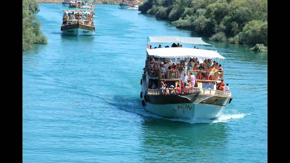 A boat named 'LACIN' with passengers on a river. 4