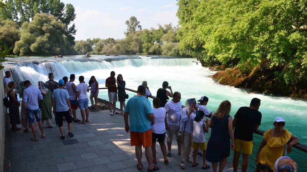A group of people observing a waterfall. 1